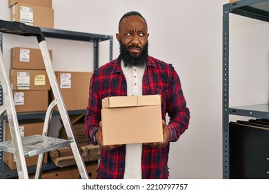 African American Man Working At Small Business Ecommerce Clueless And Confused Expression. Doubt Concept. 