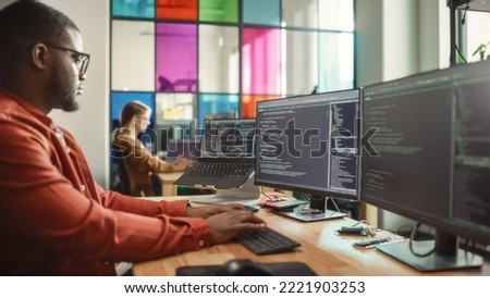 African American Man Writing Code on Desktop Computer With Multiple Monitors Set Up and a Laptop in Creative Office. Professional Data Scientist Using Software to Analyze Information From Internet. Foto d'archivio © 