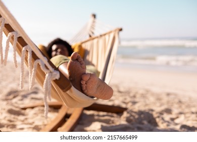 African American Mature Woman With Sand On Feet Lying On Hammock Against Sea And Sky In Summer. 