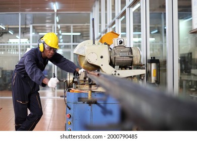 African American Mechanic Engineer Worker Wearing Safety Equipment Is Cutting Copper Tube Using Sawing Machine Inside The Factory Sawing Station