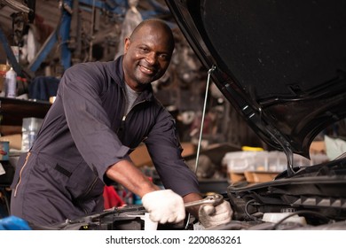 African american  mechanics - man examining car engine. Auto mechanic working in garage.Car Mechanic Detailed Vehicle Inspection. Auto Service Center Theme. - Powered by Shutterstock