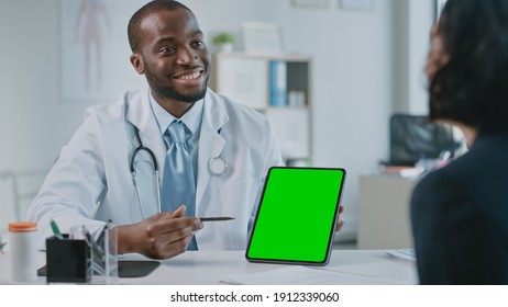 African American Medical Doctor is Explaining Diagnosis to a Patient on a Tablet with Green Screen in a Health Clinic. Assistant in White Lab Coat is Reading Medical History in Hospital Office. - Powered by Shutterstock