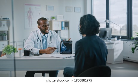 African American Medical Doctor Showing Mammography Test Results to a Patient on a Tablet Computer in a Health Clinic. Friendly Assistant Explains Importance of Breast Cancer Prevention Screening.