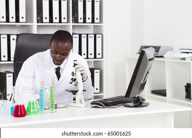 African American Medical Scientist Wearing Lab Coat With Microscope And Test Tubes In Laboratory