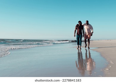 African american mid adult man walking with senior father at seashore against clear sky, copy space. Unaltered, family, together, nature, vacation, retirement, enjoyment and summer concept. - Powered by Shutterstock