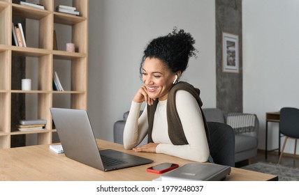 African American mixed race adult student wearing earphones having virtual meeting online call with friends, educational webinar chatting at home office. Video e learning conference call on pc.