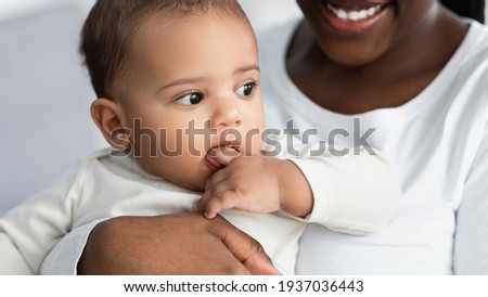 African American mom hugging her cute kid at home