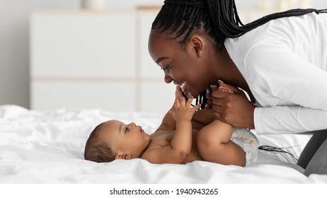 African American Mom Playing In Bed With Her Black Baby