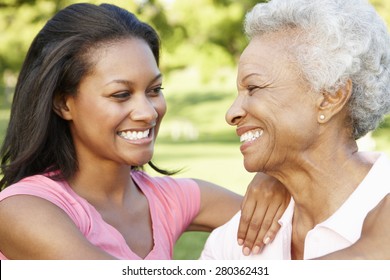 African American Mother And Adult Daughter Relaxing In Park