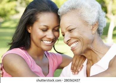 African American Mother And Adult Daughter Relaxing In Park