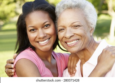 African American Mother And Adult Daughter Relaxing In Park