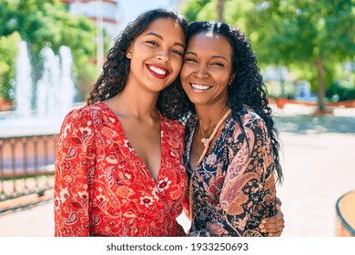 African american mother and daughter smiling happy hugging at the park.