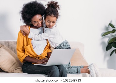 African American Mother And Daughter Watching Something On Laptop At Home