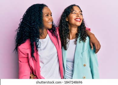 African American Mother And Daughter Wearing Business Style Looking Away To Side With Smile On Face, Natural Expression. Laughing Confident. 