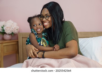 African American Mother Embrace Little Daughter Before Going To Sleep On Bed At Home. Black Mom And Girl In Bedroom. Child And Parent . Kid Hug Mum 