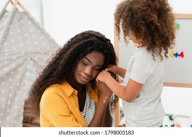 African American Mother Holding Hands With Curly Daughter