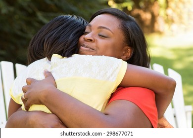 African American Mother Hugging Her Daughter.  