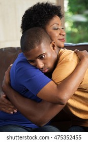 African American Mother Hugging Her Adult Son.