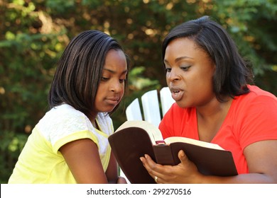 African American Mother Reading To Her Daughter