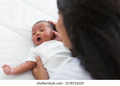 African American Mother Taking Care Her Newborn Baby On The Bed With Carefully. Closeup Of Infant With Mother. Mom And Infant Baby On Bed