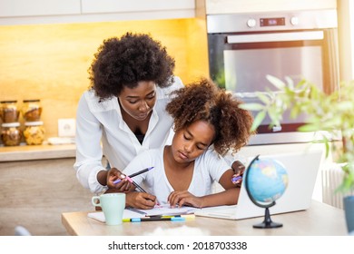 African American mother is teaching her daughter are using laptop at home together. Mother and daughter studying with laptop. Woman and child using a laptop together 