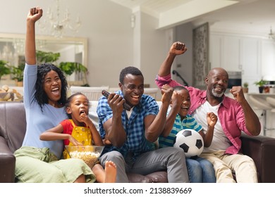 African american multi-generational family cheering while watching soccer match on tv at home. unaltered, lifestyle, sport, fans, family, watching tv, soccer match, cheering and leisure concept. - Powered by Shutterstock