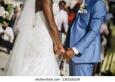 African American newlyweds hold their hands together during the ceremony - Powered by Shutterstock