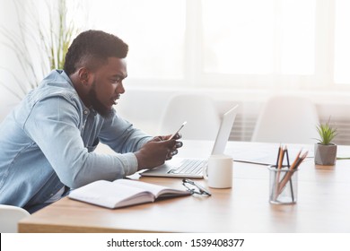African american office worker using smartphone at workplace, browsing internet or messaging, side view with copy space - Shutterstock ID 1539408377