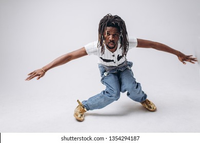 African American on a white background in jeans and a white T-shirt, emotions, emotional person