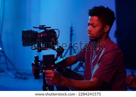 African American operator concentrating on his work, he using camera on the set
