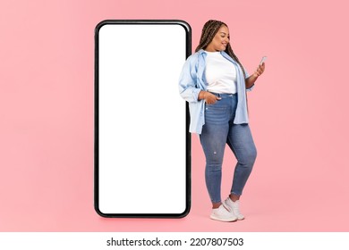 African American Oversized Lady Leaning On Big Phone With Empty Screen Texting And Using Application On Smartphone Standing Over Pink Studio Background. Mobile Communication. Mockup - Shutterstock ID 2207807503