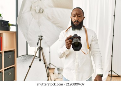 African American Photographer Man Working At Photography Studio Skeptic And Nervous, Frowning Upset Because Of Problem. Negative Person. 