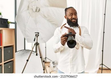 African American Photographer Man Working At Photography Studio Pointing Aside Worried And Nervous With Forefinger, Concerned And Surprised Expression 