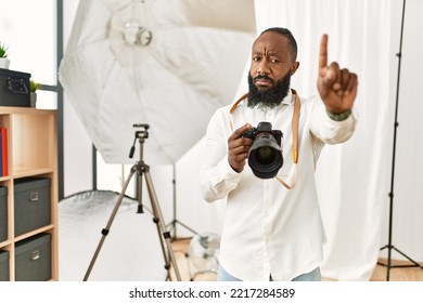 African American Photographer Man Working At Photography Studio Pointing With Finger Up And Angry Expression, Showing No Gesture 