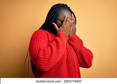 African american plus size woman with braids wearing casual sweater over yellow background with sad expression covering face with hands while crying. Depression concept. - Shutterstock ID 1803774907