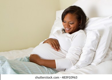 African American pregnant woman looking and holding her stomach.  