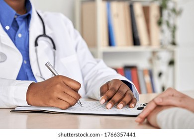 African american professional medic female doctor physician therapist gp hold pen consult woman patient filling women healthcare checkup medical form at clinic appointment visit. Close up view