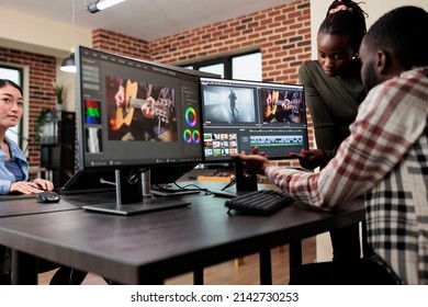 African american professional video editors enhancing digital footage using specialized software. Expert videographers in office workspace editing and improving frames on workstation.