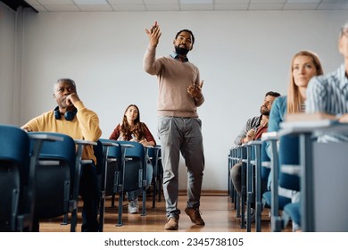 African American professor talking during a class with adult students in the classroom. - Shutterstock ID 2345738105