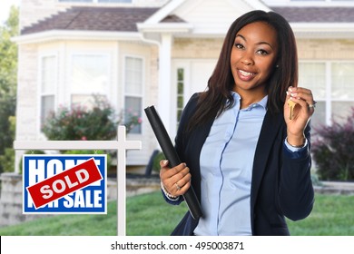 African American Real Estate Agent Holding Keys In Front Of Sold House