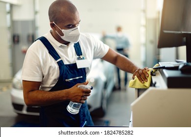 African American repairman wearing protective face mask and disinfecting his workshop during COVID-19 pandemic.  - Powered by Shutterstock