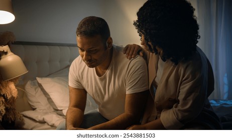 African American sad man sit on bed night evening at home suffer worried breakdown regret erectile dysfunction loving woman wife hug comforting support empathy crisis impotence potency health problem - Powered by Shutterstock