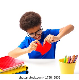 African American School Boy, Teenager Tears Appart Valentines Heart With Angry Face. Isolated, Over White Background, With Copy Space.