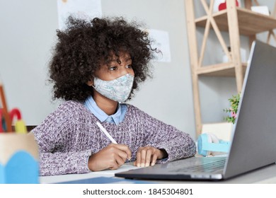 African American School Kid Child Girl Wearing Face Mask Watching Online Class Live Stream Lesson Virtual Distance Learning Remote Education Looking At Laptop Computer Studying At Home Classroom Desk.