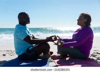 African american senior couple meditating while practicing yoga at beach on sunny day. unaltered, love, togetherness, fitness and active lifestyle concept. - Powered by Shutterstock