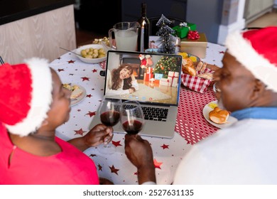 African american senior couple in santa hats on christmas laptop video call with female friend. christmas, festivity and communication technology. - Powered by Shutterstock