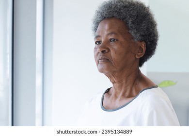 African american senior female patient looking out window in hospital room. Medicine, healthcare and medical services, unaltered. - Powered by Shutterstock