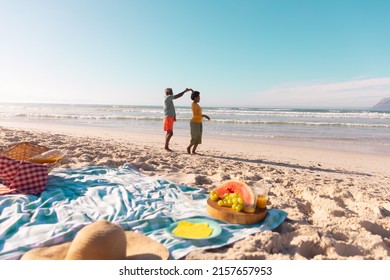 African American Senior Man Dancing With Mature Woman At Beach Against Sea And Blue Sky In Summer. 