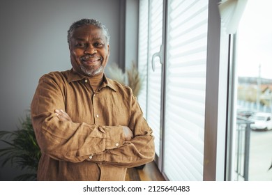 African American Senior Man at home Portrait. Smiling senior man looking at camera. Portrait of black confident man at home. Portrait of a senior man standing against a grey background