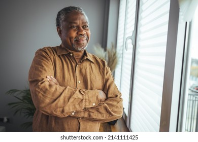 African American Senior Man at home Portrait. Smiling senior man looking at camera. Portrait of black confident man at home. Portrait of a senior man standing against a grey background - Powered by Shutterstock